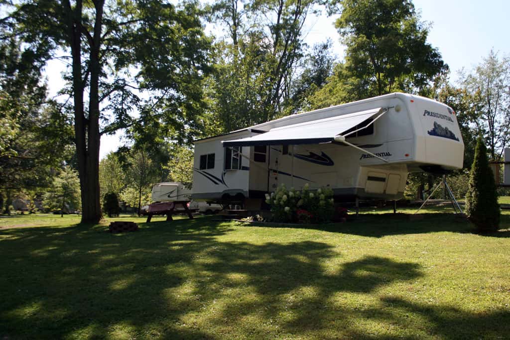 A white rv parked in a grassy area.