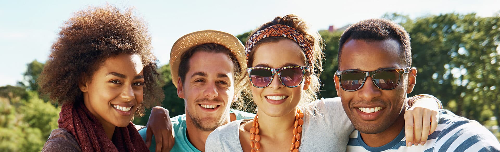 A group of people smiling together in a park.