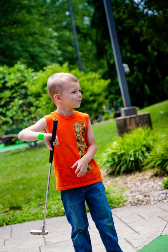 A young boy holding a golf club.