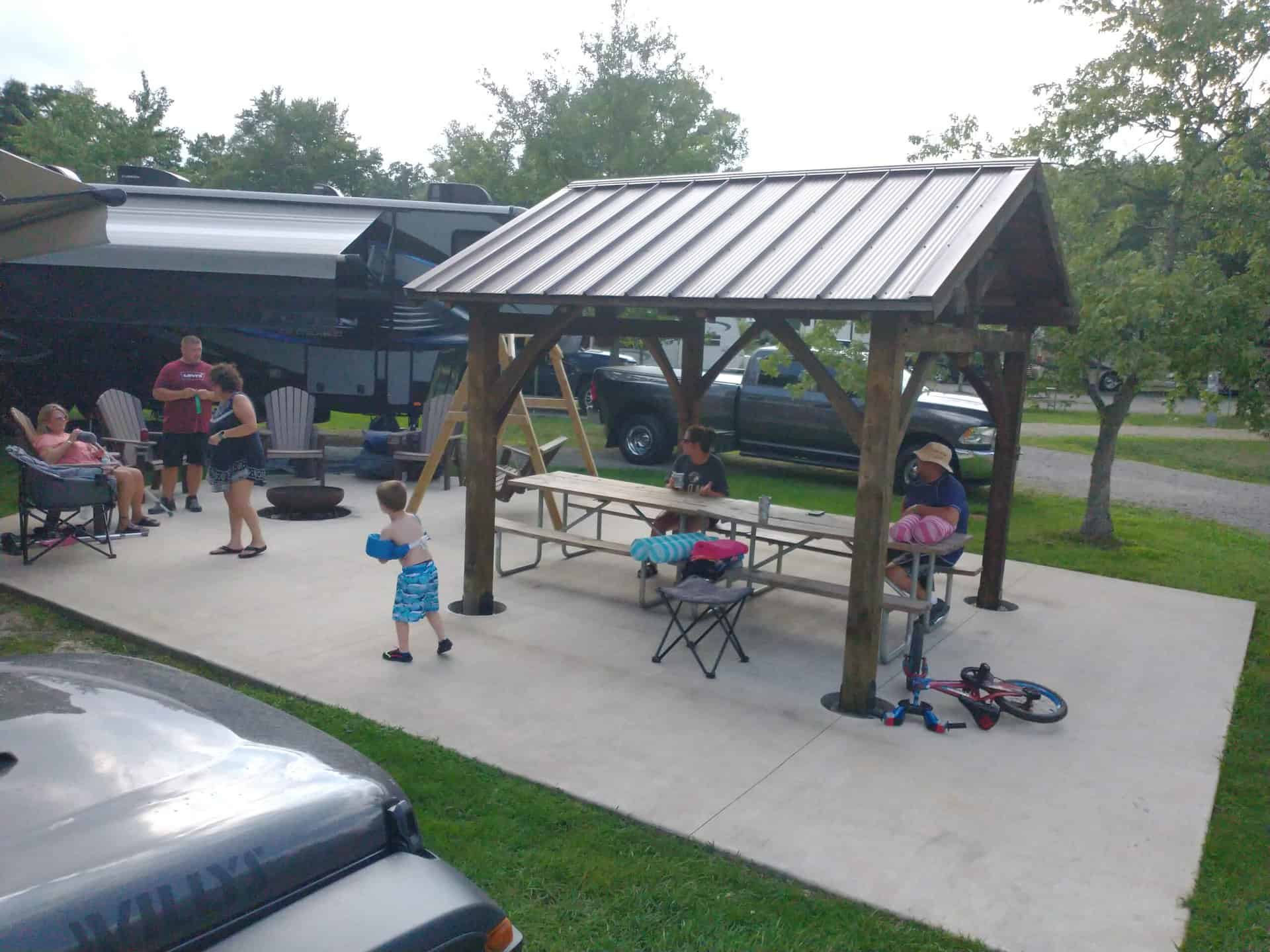 A group of people enjoying a picnic at a campsite. A group of people enjoying a picnic at a campsite.