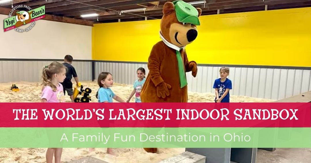 Children play in a large indoor sandbox with a person in a Yogi Bear costume standing nearby. Text reads: "The World's Largest Indoor Sandbox. A Family Fun Destination in Ohio.