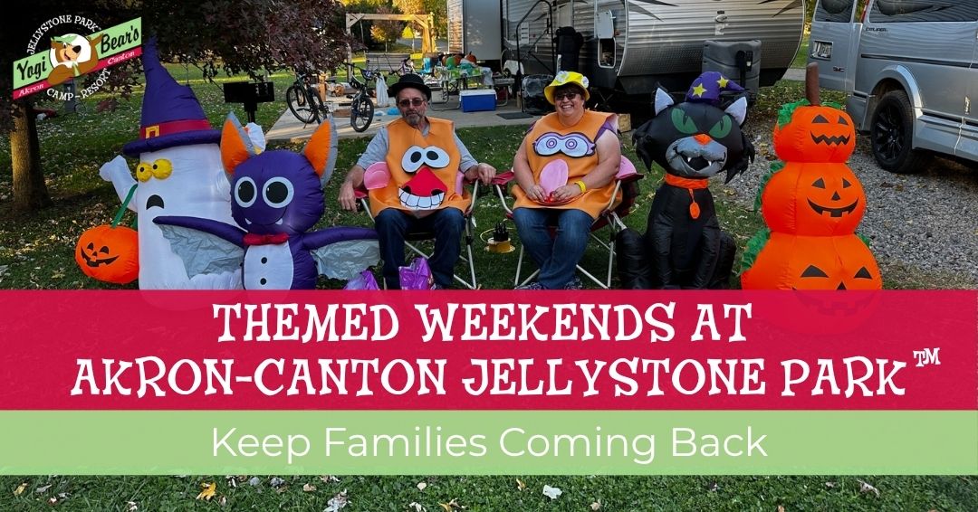 Two adults in costumes sit outside RVs with Halloween decorations, including inflatables of pumpkins, a bat, and a cat. Text advertises themed weekends at Akron-Canton Jellystone Park.