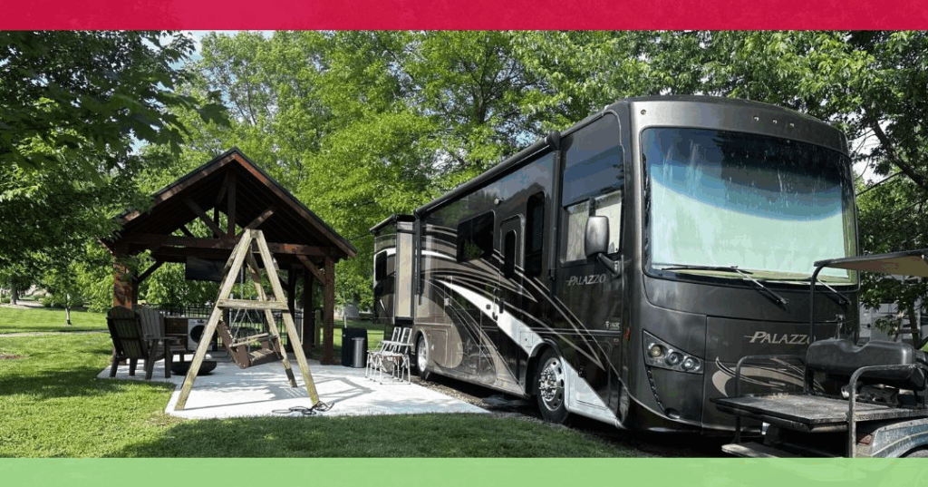 A black rv parked next to a wooden structure.