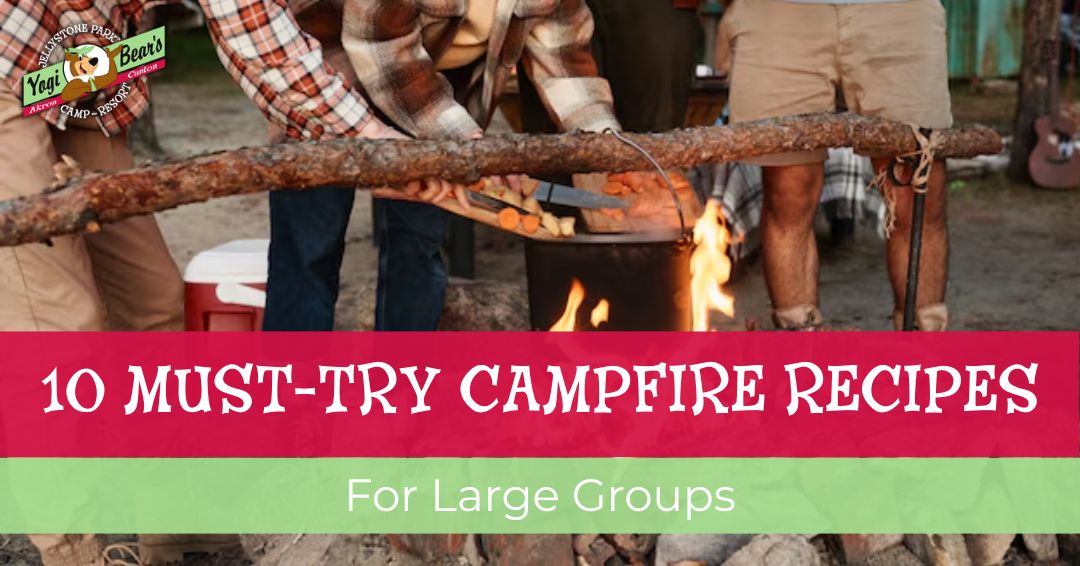 Three people cooking over a campfire with text overlay: "10 Must-Try Campfire Recipes for Large Groups.
