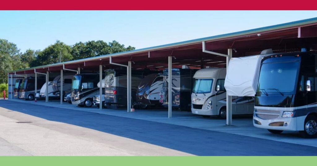 A row of recreational vehicles (RVs) parked under a large covered parking structure on a sunny day.