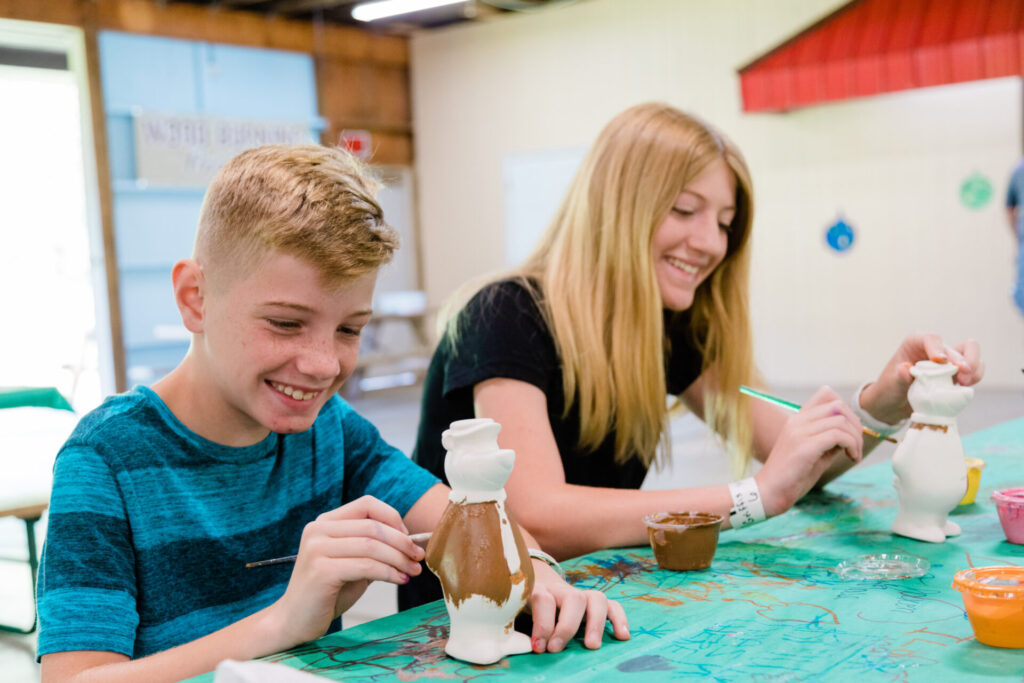 A boy and girl painting a bear.